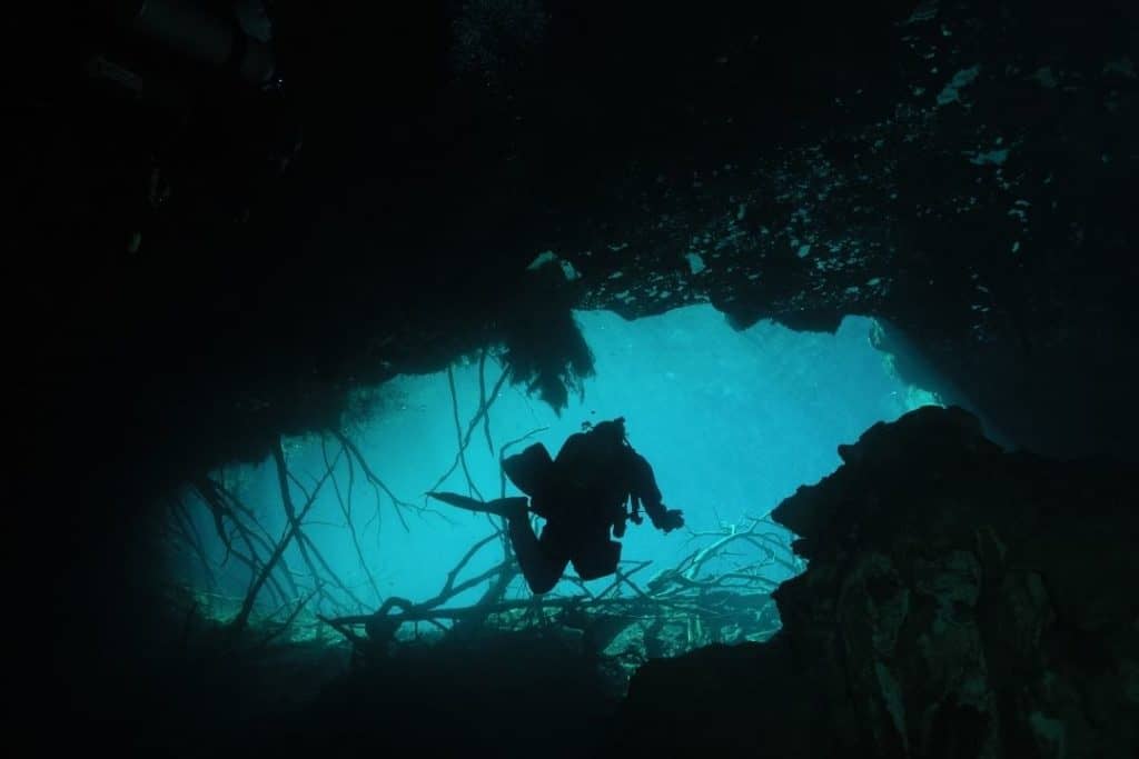 scuba diver entering a cave
