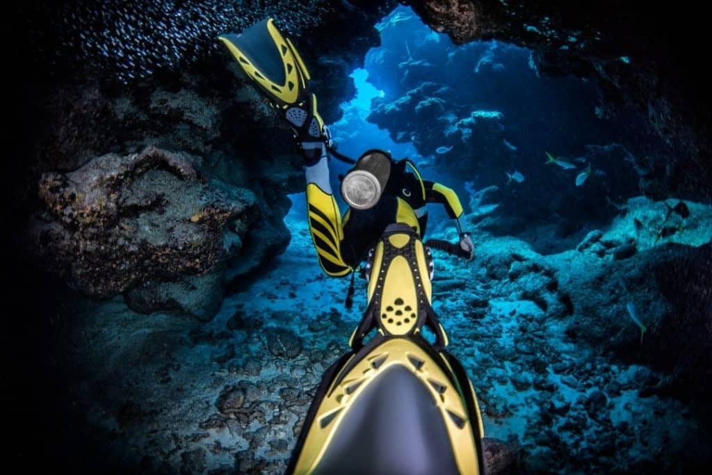 un plongeur qui passe dans une cave sous marine