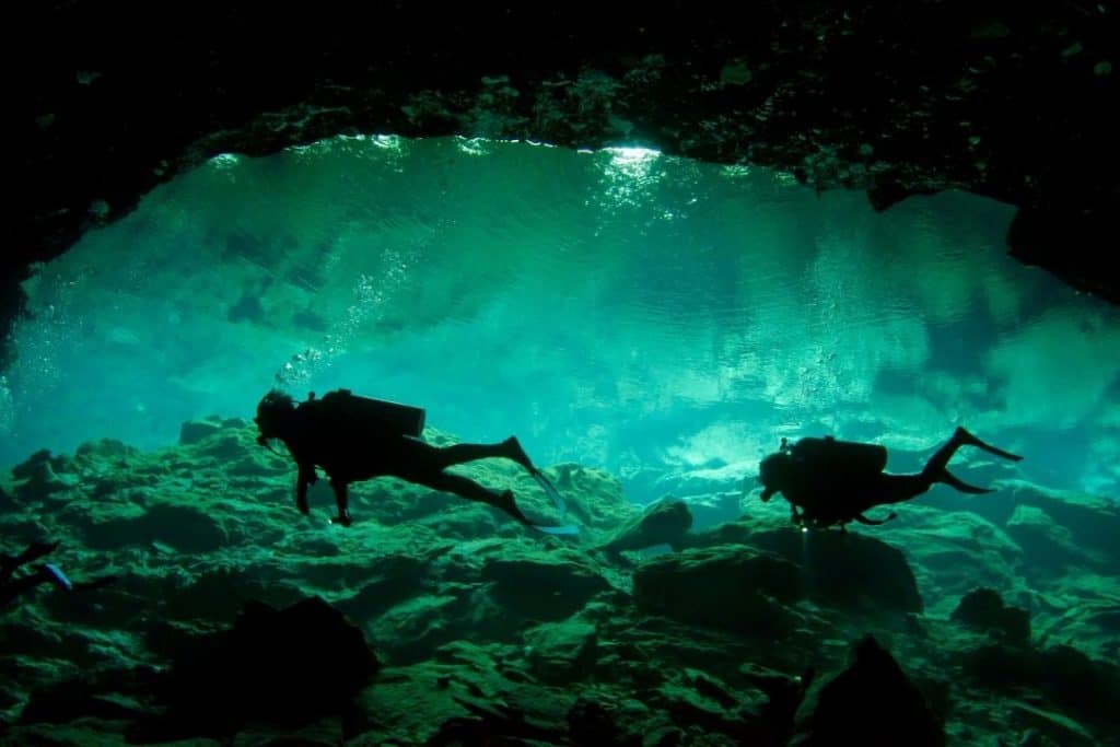 scuba divers in a cenote