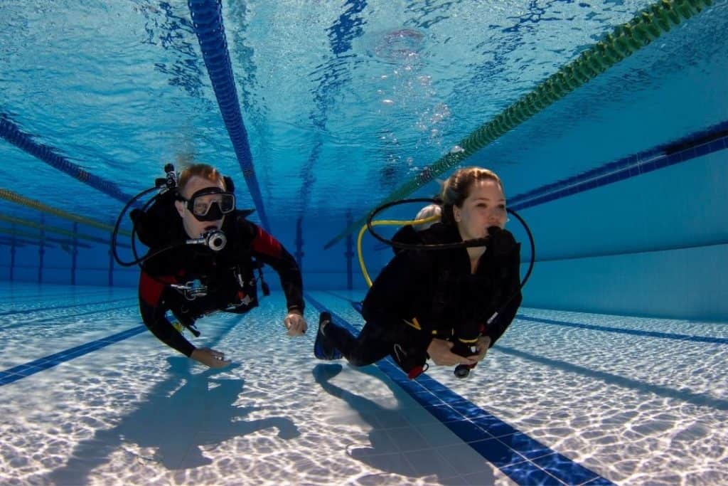 scuba diving student and her instructor under water