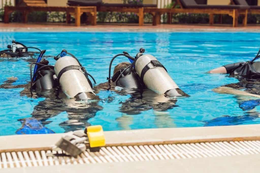 scuba divers learning in a pool