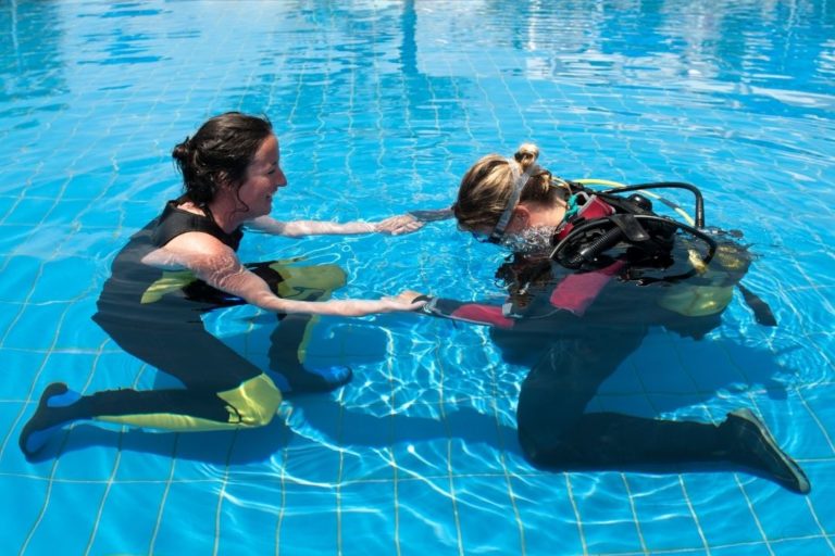 woman learning to use scuba diving equipment in a pool