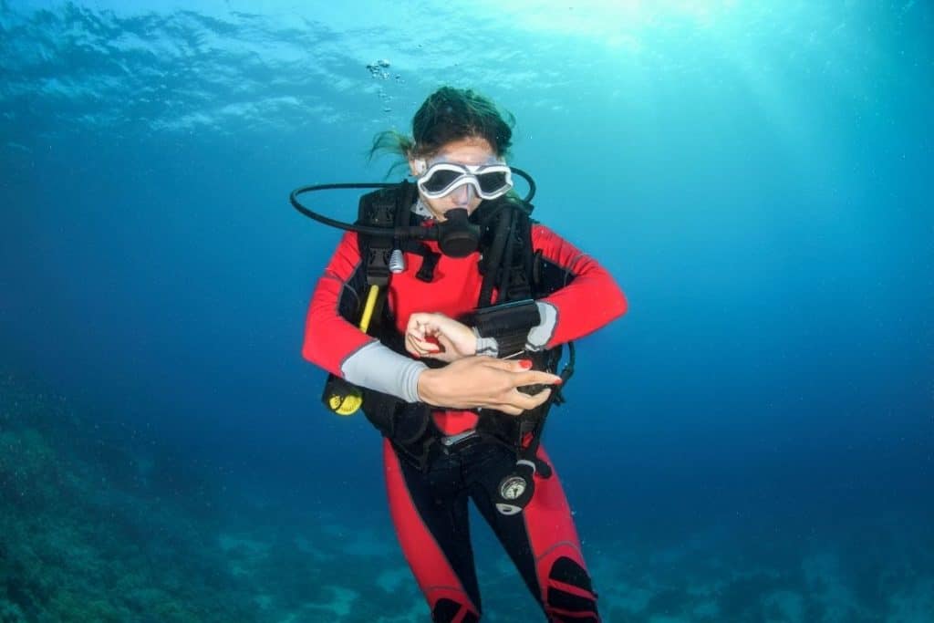 scuba diver looking at her dive computer underwater