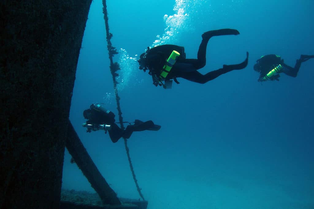 Three Scuba Divers at the Stern Gate of the U.S.S. Spiegel Grove Wreck in Key Largo